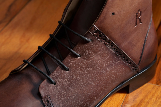Close-up of The Rafter Club Italian made mens dress shoe in brown leather with black laces on wooden floor