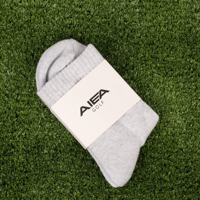 AIEA Golf gray socks on grass showcasing fashionable womens golf clothing accessory
