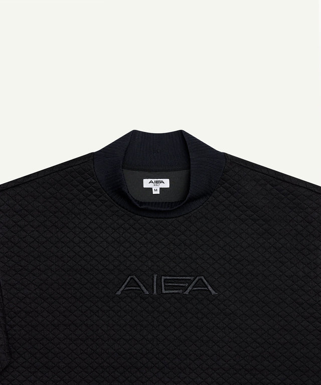 Black quilted pullover top from AIEA Golf featuring fashionable womens golf clothing with embroidered logo
