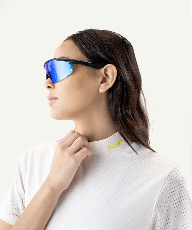 AIEA Golf fashionable womens golf clothing white textured top with yellow logo and blue reflective sunglasses
