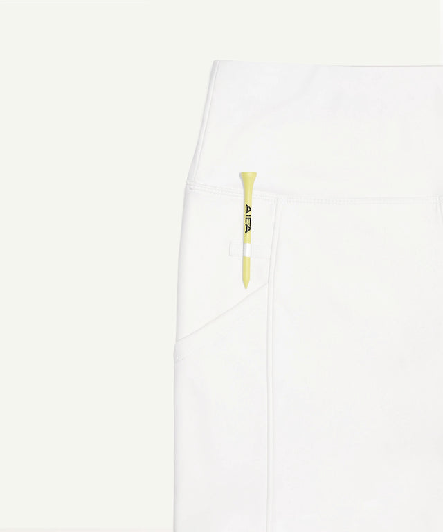 White AIEA Golf skirt pocket with yellow golf tee showcasing fashionable womens golf clothing