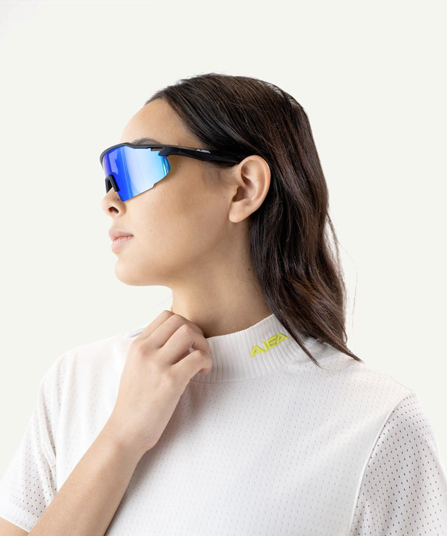AIEA Golf fashionable womens golf sunglasses with blue mirrored lenses worn by model in white golf apparel