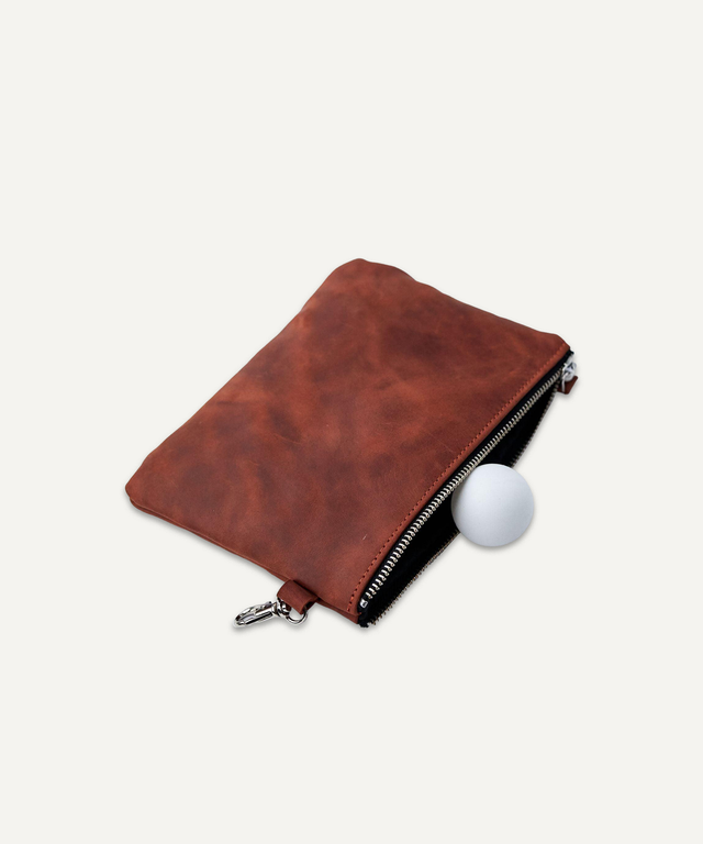 Pikore brown leather golf field pouch with zipper partially open showing a white golf ball