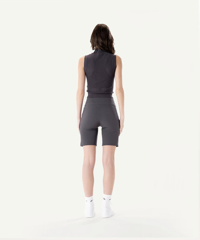 Back view of a woman wearing AIEA Golf sleeveless top and fitted shorts stylish fashionable womens golf clothing