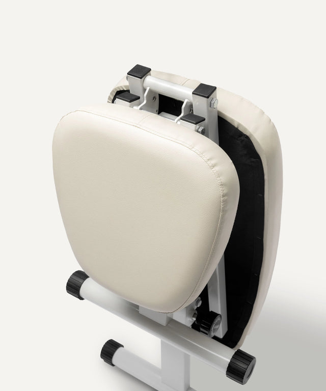 Folded WeGym adjustable fitness bench with white cushioned padding and sturdy frame