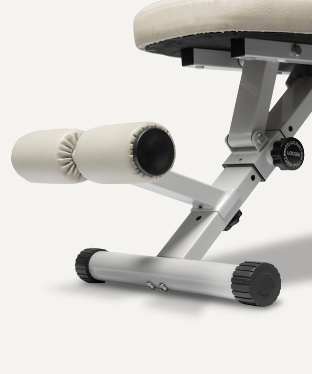 Close-up of WeGym adjustable fitness bench leg and padded roller support in beige and gray