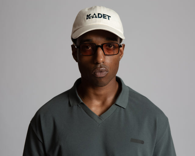 Man wearing a Kadet logo cotton twill hat in white with black embroidered lettering