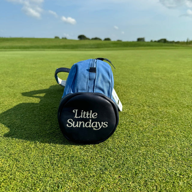 Little Sundays kids golf bag in blue on green golf course with kids golf clubs inside