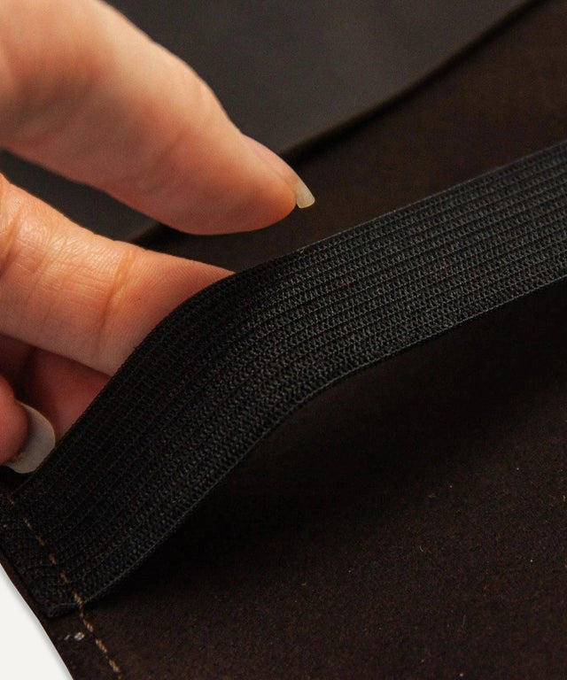 Close-up of hand holding black elastic strap inside Pikore leather golf scorecard holder accessory