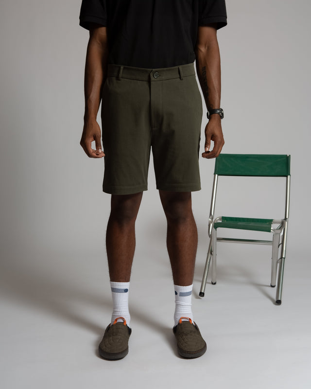 Kadet men's chino shorts in olive green worn with black shirt and brown shoes