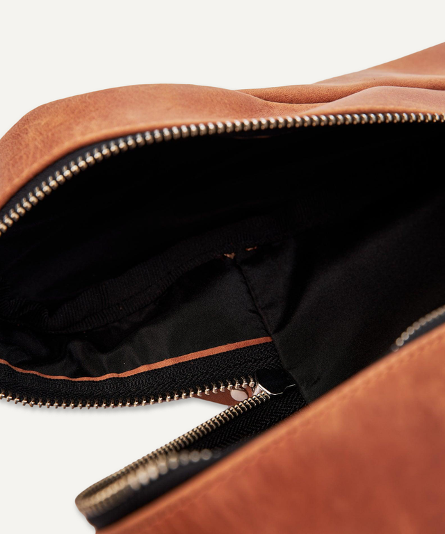 Close-up of Pikore leather golf shoe bag zipper and black interior lining in brown leather