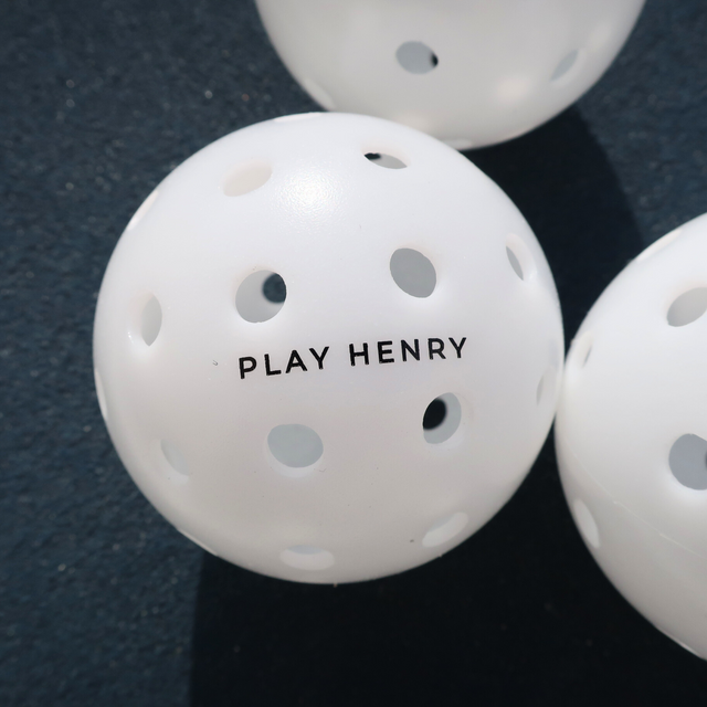 Play Henry white outdoor pickleball balls with multiple holes for improved flight and durability