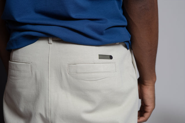 Kadet pleated chino pants for men in light beige shown from the back with welt pockets