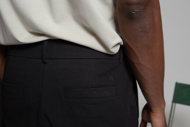 Kadet black pleated chino pants for men showing back pocket and waistband details