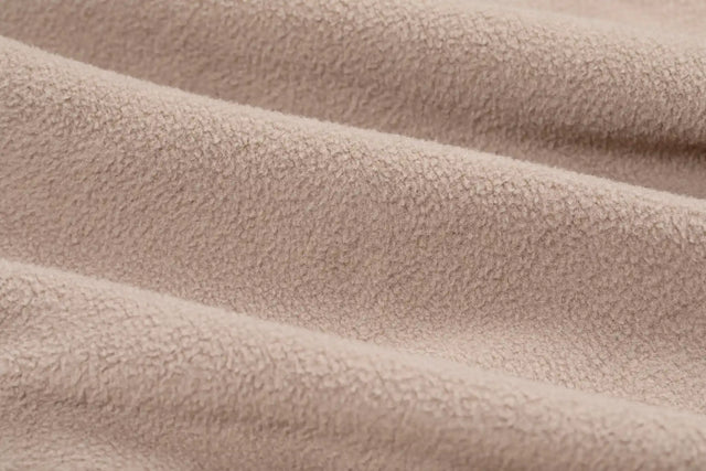 Close-up view of beige fleece fabric texture from Solstice Athletics premium workout clothing