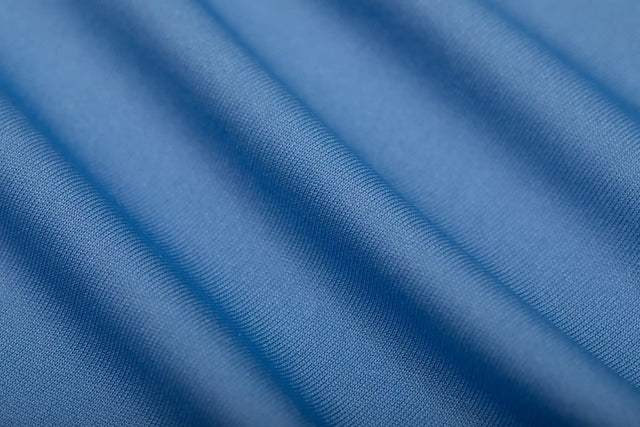 Close-up of blue fabric texture showcasing premium workout clothing from Solstice Athletics