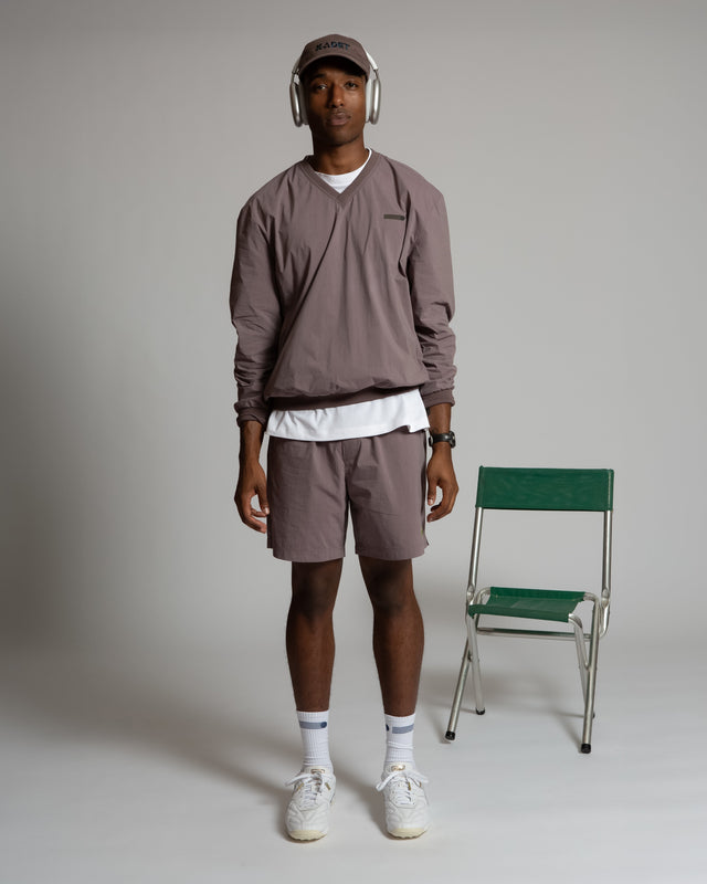 Kadet women's pull-on athletic shorts in muted purple worn with matching long sleeve top and cap