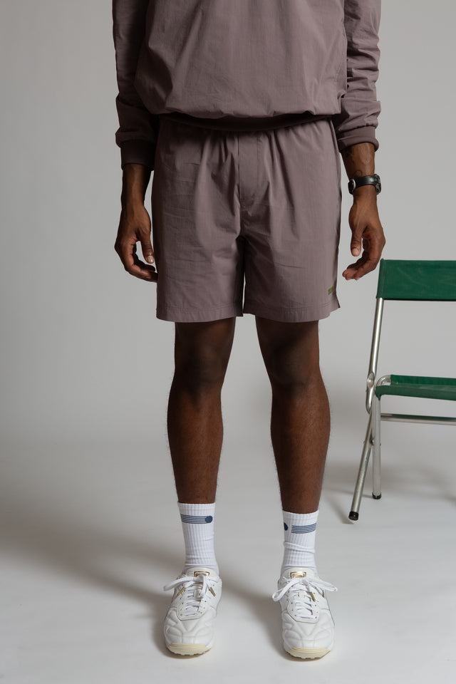 Kadet women's pull-on athletic shorts in muted purple worn with matching top and white sneakers