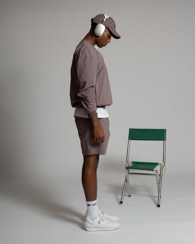 Kadet women's pull-on athletic shorts worn by model in casual brown outfit with white sneakers and headphones