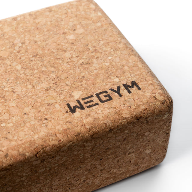 WeGym cork yoga block close-up showing natural cork texture and logo on white background