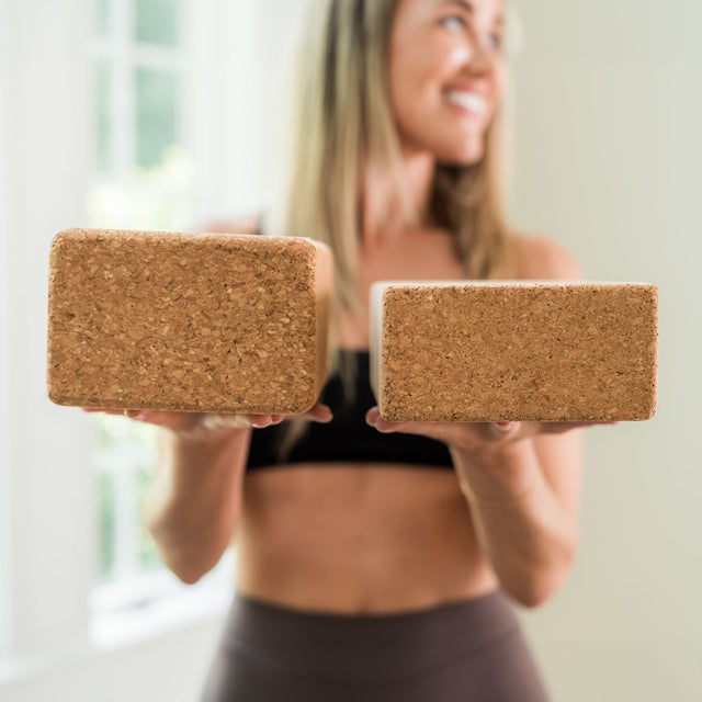 WeGym cork yoga block held by woman in workout clothes for yoga and fitness practice
